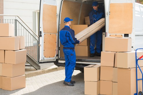 Furniture pick-up team handling bulky items in a London residential street