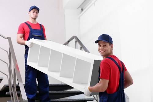 Local crew navigating narrow stairs during a London furniture collection