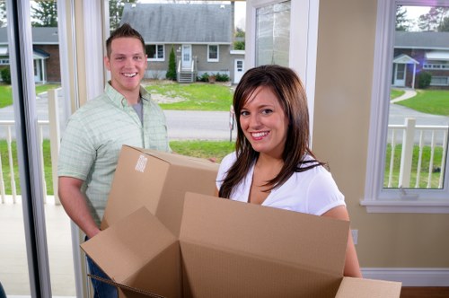 Moving team navigating London flats and stairs with household items
